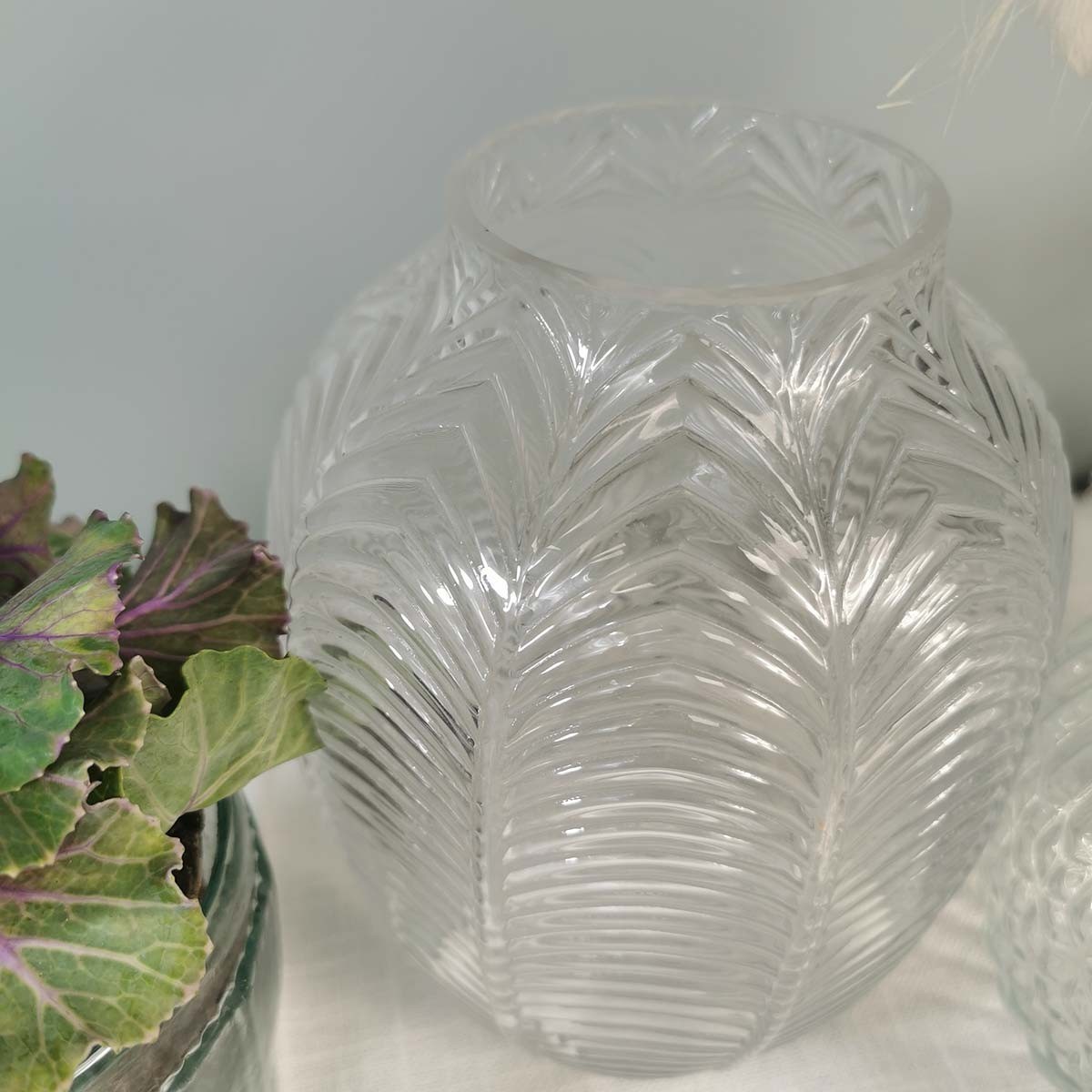 Composition Vase en verre arrondi transparent motif feuilles